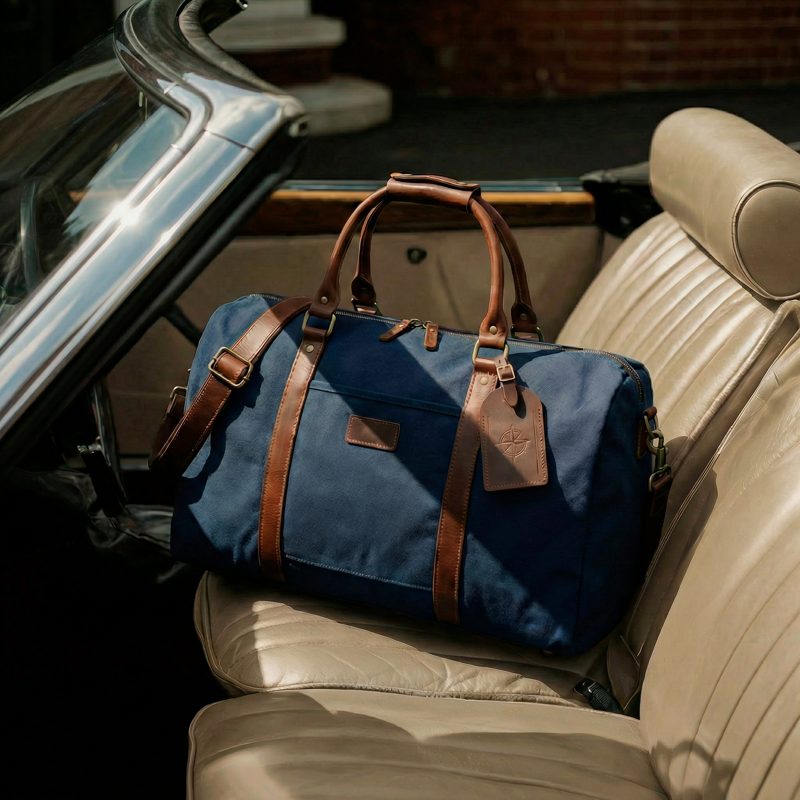 Nachher: dieselbe Reisetasche auf dem Ledersitz eines Oldtimers, KI-generiertes Interieur